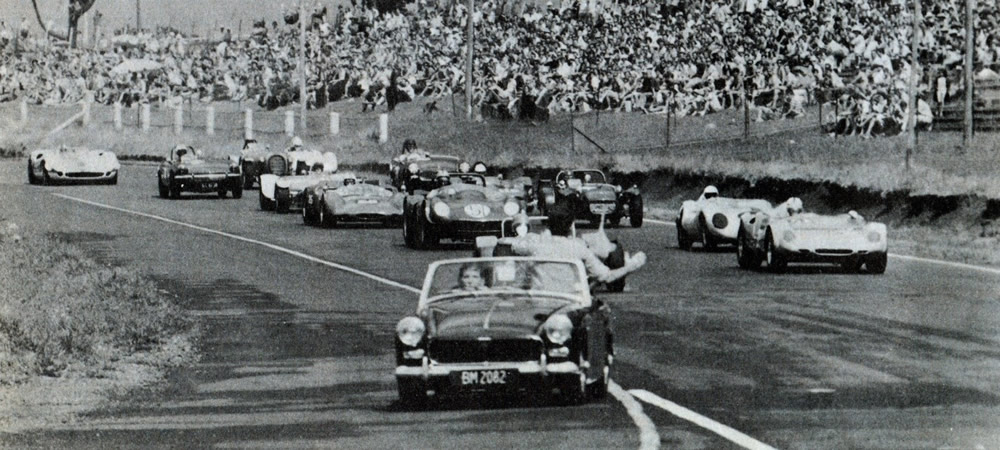 Pukekohe 8 March 1970 – Rolling start for a Sports car race – On the front right of the photo is Ivy Stephenson in her Lotus 23B, and behind her is Dave Wallace in his Lola Mk1 Climax. Jamie Aislabie #51 Cooper Jaguar 3.8 is the second car behind the Safety Car, with Jim Boyd in his Lola T70 Chev at the rear of the grid – photo Motorman magazine Apr 70, page 22