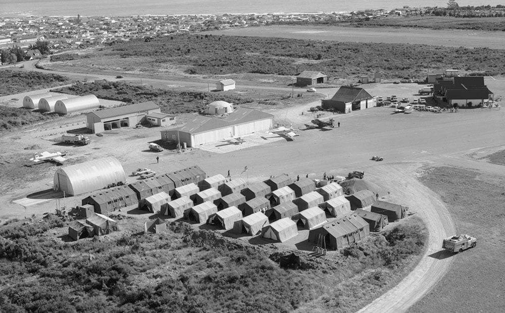 Ex Falcons Roost 15, Hokitika Apr 20th-29th 1982 – 14 Sqn tented camp – Shower and toilet tents bottom right, the big tents on left side are cookhouse and Mess/Bar tents, accommodation tents in centre, Flight Line and Servicing Flt tents fronting aircraft parking area. One SMR is on the parking ramp near the biggest hangar. Hokitika township and Tasman Sea in the background - photo RNZAF OhG1230-82