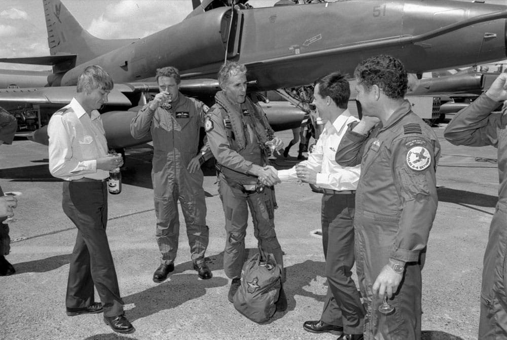 From left -Sqn Ldr Nick Pedley (14 Sqn), Sqn Ldr Gordon Alexander (CO 14 Sqn), Wg Cdr Jim Barclay (OC Strike Wing) being congratulated by Sqn Ldr John Duxfield (Strike Wing Exec Officer), Wg Cdr Frank Sharp (CO 75 Sqn) and Skyhawk TA4K NZ6251 in the background – photo RNZAF OH G2540-87