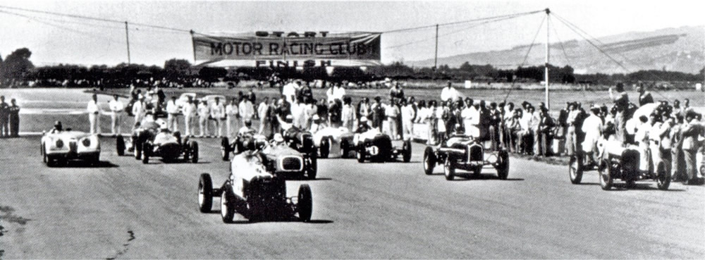 Wigram 28 Feb 53 – Heat 2 12 laps - George Smith leads in his Gee Cee Ess. John Jacobsen on the right in his JJ Ford V8 had started quickly to be in 2nd place. Behind and to the right of Smith is Hec Green’s RA-Vanguard with the white noseband, and to the right of Green’s RA is Ron Roycroft in his Alfa Romeo P3. Les Holden’s light coloured Jaguar XK120 is on the left of this photo – photo ‘Up to Speed’ page 163