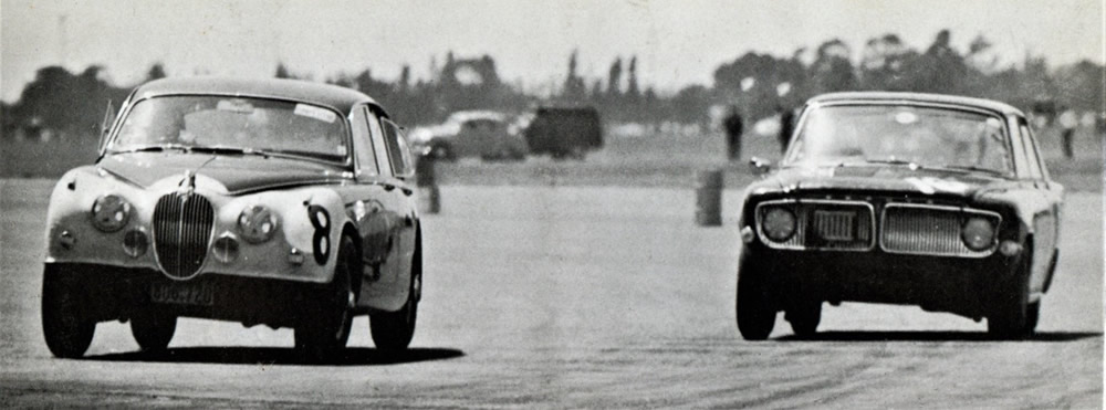 Wigram 18 Jan 64 - #8 Ray Archibald Jaguar Mk2 3.8, and #16 Ernie Sprague Ford Zephyr Mk3, at speed around the Control Tower bend – photo 1964 Shell Book