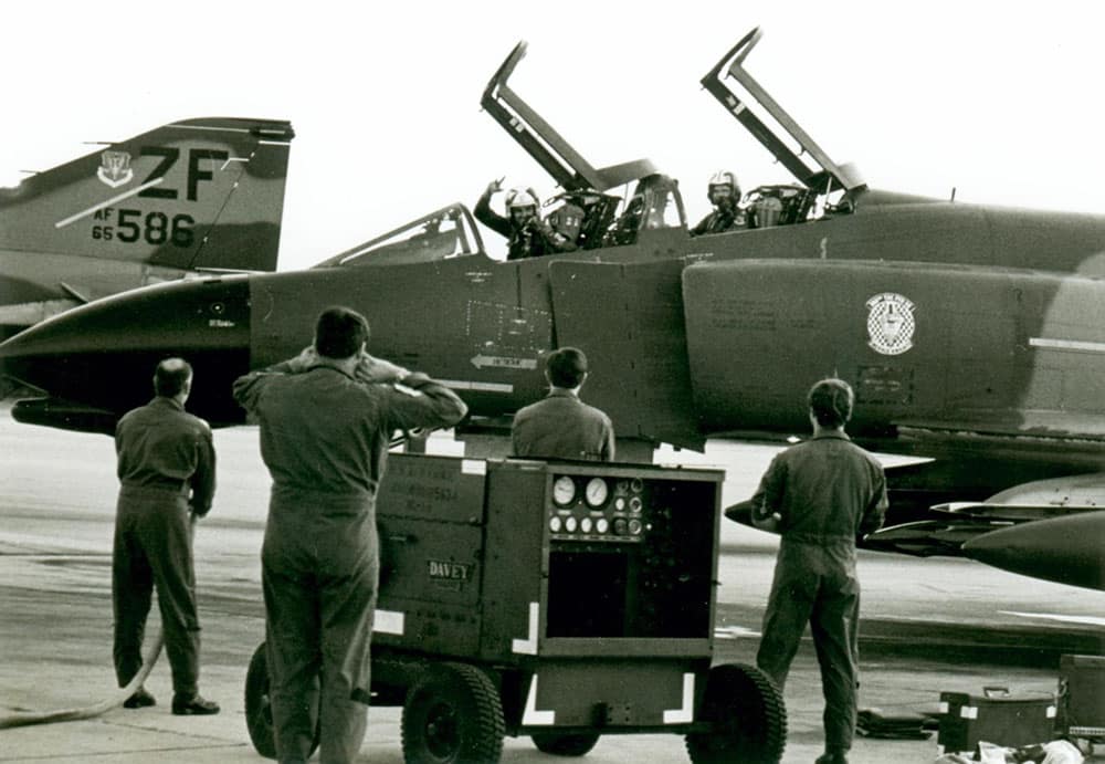 USAF Homestead AFB, Florida, 26 Jan 82 – Sqn Ldr Jim Barclay in the front cockpit on final flight in USAF Phantom F4D 65-497 with the 308th Squadron, 31st Tactical Fighter Wing; fire hose at the ready by Lt Col Tom Lanum on the left, and fellow 308th ‘wellwishers’ – photo Jim Barclay